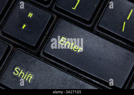 Black keyboard with enter keys in green color. High detail macro photo of keyboard keys Stock Photo
