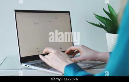 Tallinn, Estonia - 2025.03.08: Woman interacting with ChatGPT AI on a computer. Stock Photo