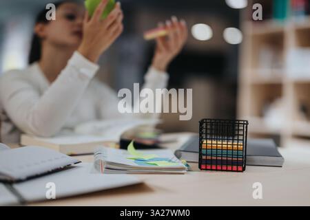 Focused woman studying with colorful sticky notes in library Stock Photo