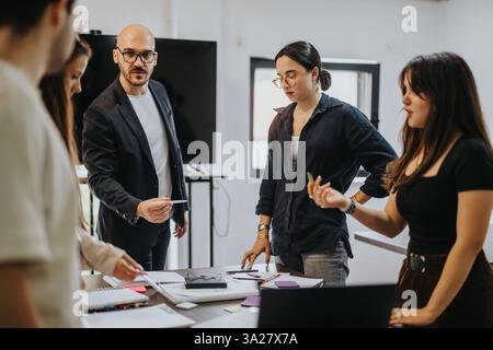Students collaborating on project with professor support and guidance Stock Photo