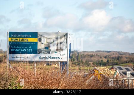 Large Bovis Homes sign board on the edge of a new house development with new homes being built in the background. Stock Photo