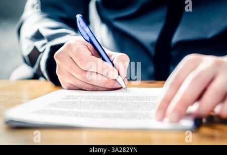Settlement signature. Acquisition or buyout. Man signing insurance document. Car loan, lease or rental paper contract. Merger or business offer deed. Stock Photo