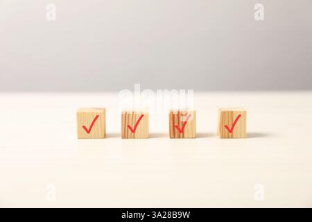 Wooden cubes with check marks on light table Stock Photo