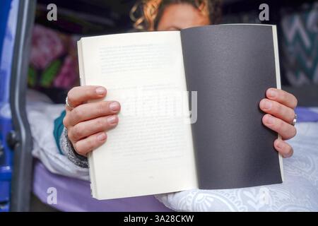Reading in the Camper: A Joyful Woman Celebrates Sant Jordi Stock Photo