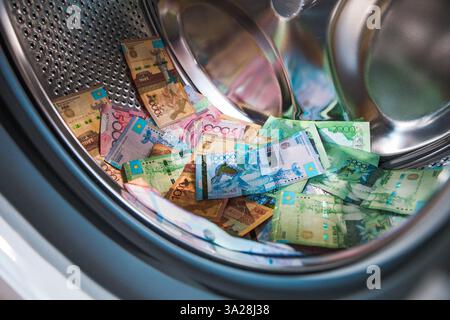 A pile of tenge bills lies in the drum of a washing machine. Money laundering. Cashing out Stock Photo