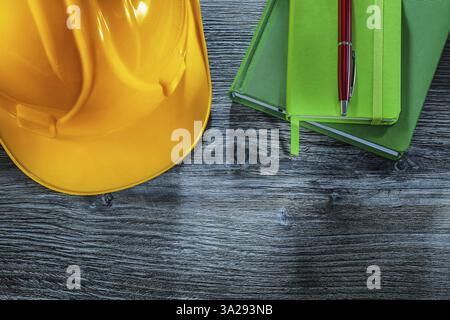 Set of notebooks pen building helmet on wooden board Stock Photo