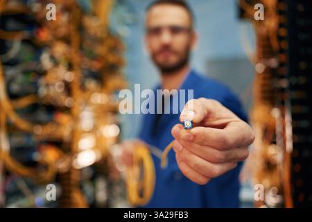 Close up view of man hand that is holding internet cable. Stock Photo