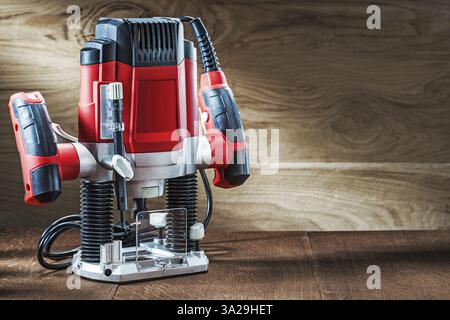 Side view red speed variable power small plunge router milling machine portable electric hand mini wood router on wooden background Stock Photo