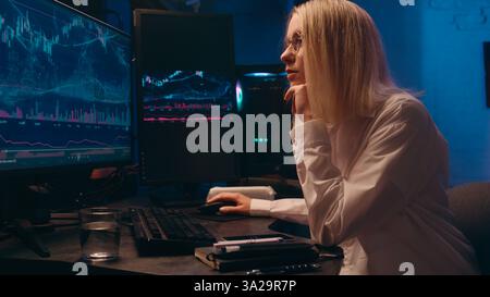 Computer late night work online crypto trading chart Caucasian business woman programmer hacker coder businesswoman broker trader thinking analyzing Stock Photo