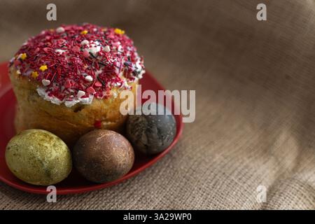 Easter cake with three Easter eggs in a red plate on the table Stock Photo