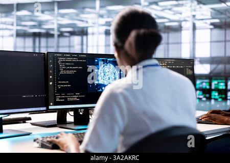 Server hub IT expert using AI systems to input data faster during complex computational tasks. African american woman in data center using artificial intelligence parallel processing tech Stock Photo