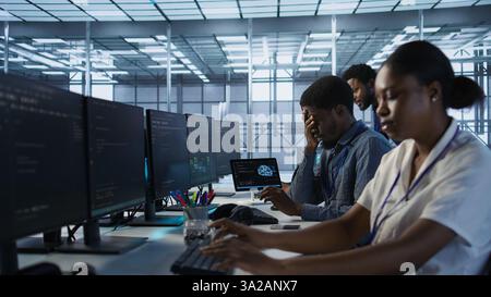 Tired data center engineer yawning, suffering from lack of sleep while maintaining company network infrastructure. Bored server hub worker feeling fatigued, struggling to stay awake, camera A Stock Photo