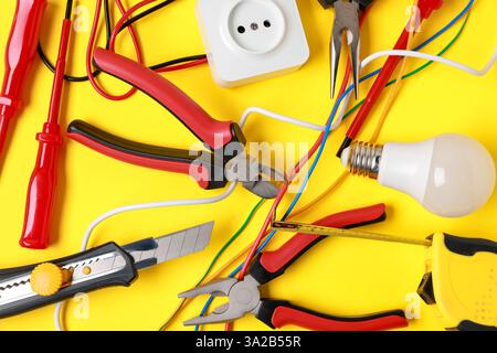 Different electrical tools on yellow background, flat lay Stock Photo
