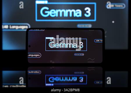 Smartphone screen displaying Google Gemma 3 AI model, with a larger screen in the background. The image emphasizes artificial intelligence and digital Stock Photo
