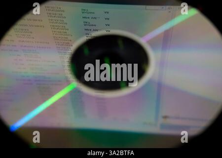 CD or DVD reflecting a set of data displayed on a monitor Stock Photo