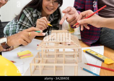 Architects and engineers are pointing out housing projects. Architect explaining project plan to clients. Confident businesswoman holding architectura Stock Photo