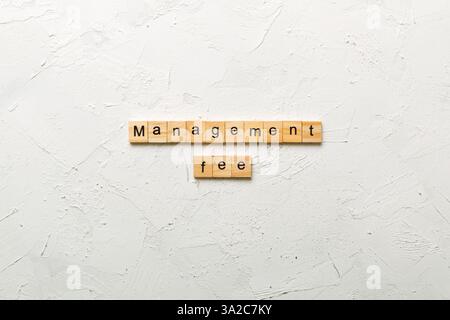 management fee word written on wood block. management fee text on cement table for your desing, concept. Stock Photo