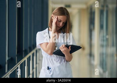Female doctor in white coat is in the hall. Stock Photo