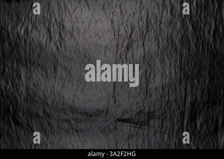 A dark fur texture with subtle highlights and shadows lies on a surface, showcasing the intricate details and rich texture of the fabric. Stock Photo