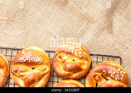 Pretzels on a black lattice against a background of canvas fabric. Space for text. View from above. Flat layout. High quality photo Stock Photo