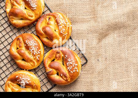 Pretzels on a black lattice against a background of canvas fabric. Space for text. View from above. Flat layout. High quality photo Stock Photo