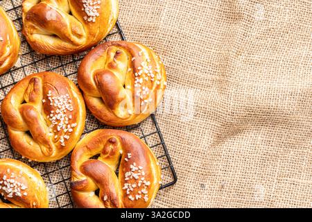 Pretzels on a black lattice against a background of canvas fabric. Space for text. View from above. Flat layout. High quality photo Stock Photo