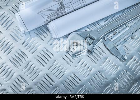 Vernier caliper construction plans adjustable spanner on channeled metal background Stock Photo