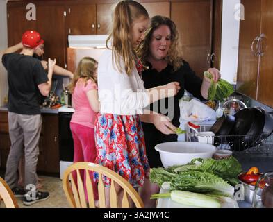 May 19, 2014 - Everett, WA, USA - Charity Edwards, from right, and her youngest daughter Ellie Edwards, 6, second right, prepare a salad for dinner on Monday, May 19, 2014, in Everett, Wash. Edwards other children Noah Powell, 15, from left, Nate Powell, 17, and Riitta Edwards, 11, check on the pasta and sauce for the main dish.  Sen. Patty Murray (D-WA) proposed legislation Wednesday, May 21, 2014, to give poor families $150 per child to spend on food during the summer months. (Credit Image: © Kevin Fujii/MCT/ZUMAPRESS.com) Stock Photo