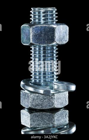 Threaded construction nut screwbolt spring washer on black surface Stock Photo