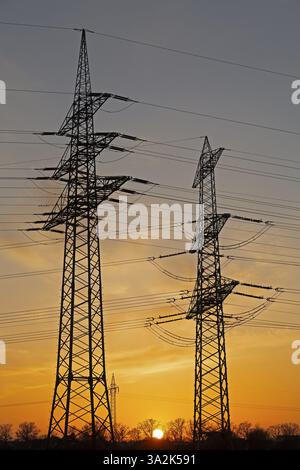 Sunset behind high-voltage pylons, Haecklingen, Lueneburg, Lower Saxony, Germany, Europe Stock Photo