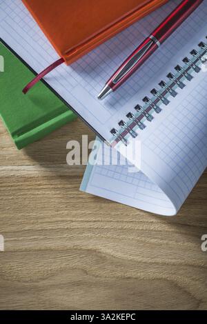 Set of spiral checked copybook notebooks pen on wooden board Stock Photo
