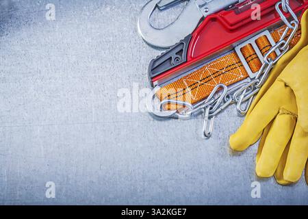Safety belt protective gloves construction level on metallic background Stock Photo