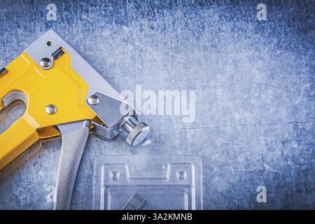 Set of stapler gun chrome staples on scratched metallic background Stock Photo