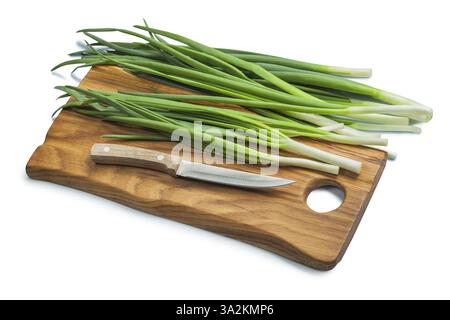 Stack Of Green Onions And Kitchen Knife On Wooden Chopping Board Isolated Stock Photo