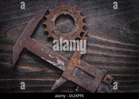 Rusted antique measuring calipers with gear wheel on vintage dark ...