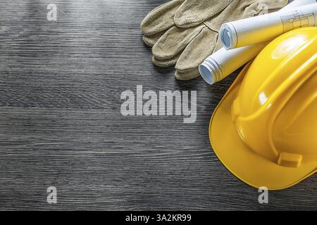 Safety gloves construction plans hard hat on wooden board Stock Photo
