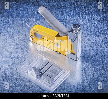Stapler gun metal staples on metallic background Stock Photo