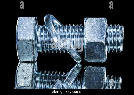 Stainless nut screwbolt spring washer on black surface Stock Photo