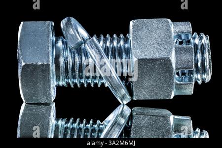 Stainless construction nut screwbolt spring washer on black surface Stock Photo