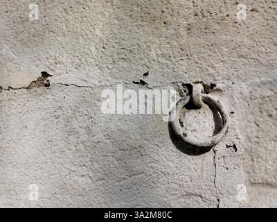 Weathered wall with iron ring showcasing texture and historical charm in an urban environment Stock Photo