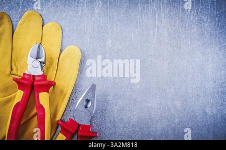 Safety gloves pliers wire-cutter on metallic background copyspace electricity concept Stock Photo