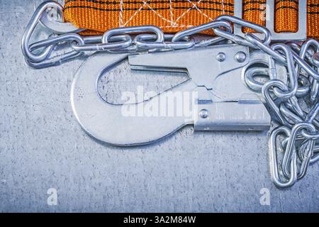 Safety belt metal chain carabiner on scratched metallic background directly above Stock Photo