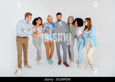 Diverse group of professionals collaborating in formal attire, sharing ideas during a productive business meeting Stock Photo