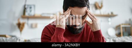 Handsome senior man contemplates his thoughts in a warm, inviting home environment. Stock Photo