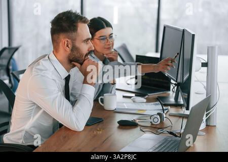 Analyzing information. Two employees are working in the office together. Stock Photo