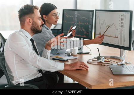 Two employees are working in the office together. Stock Photo