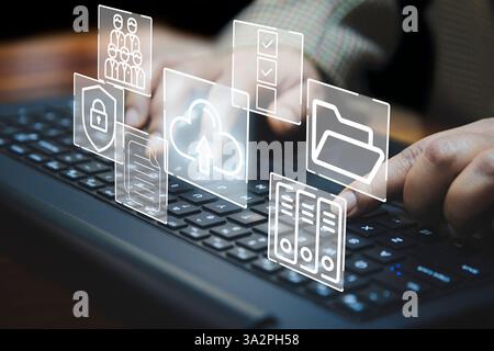 A business woman interacts with digital icons represent online document storage, cloud upload, and data security. The image symbolizes modern technolo Stock Photo