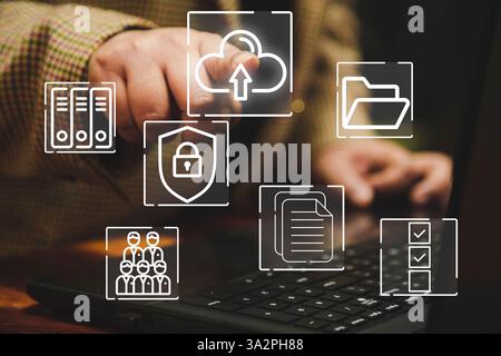 A business woman interacts with digital icons represent online document storage, cloud upload, and data security. The image symbolizes modern technolo Stock Photo