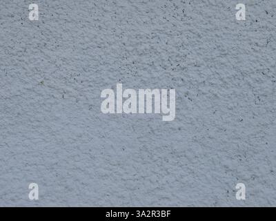plastered wall with a layer of whitewash and uneven decorative coating, a fragment of decorative plaster on a wall with a granular pimply relief Stock Photo