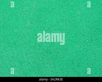 green single color textured grainy background material close-up full frame, rubber crumb coating for sports and fitness and for paving playgrounds Stock Photo